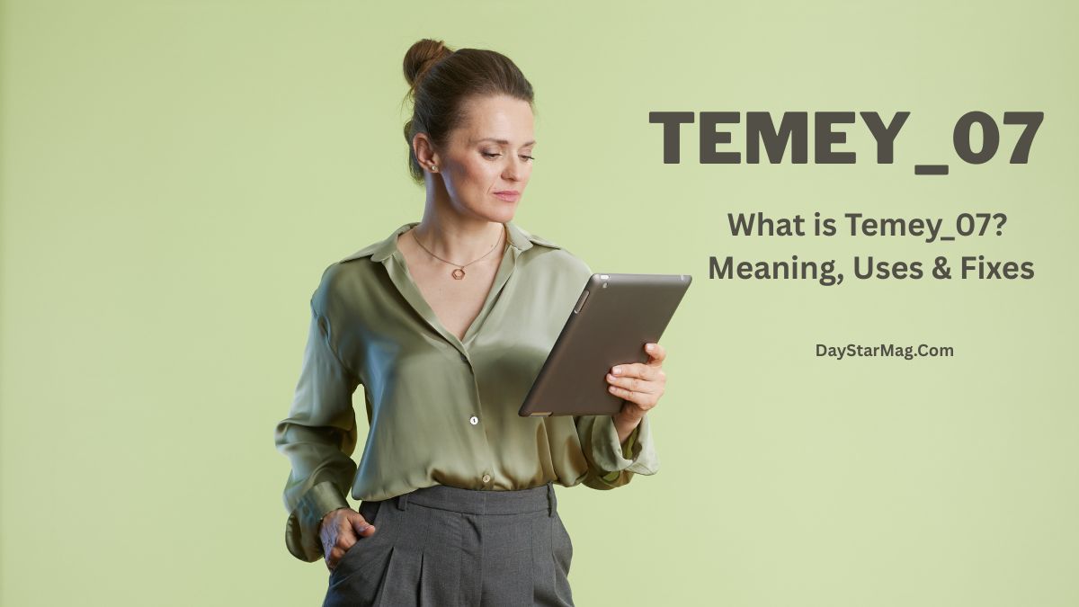 A woman standing against a light green background is holding and looking at a tablet. She is wearing a light green blouse and gray trousers, with her hair tied back. To the right of her, large text reads “TEMY_07” and below it, smaller text says “What is Temey_07? Meaning, Uses & Fixes – DayStarMag.com.”