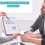 A financial advisor shows charts and graphs on a clipboard to a smiling couple during a consultation. Text on the image reads “Financial Guidance onTPEconomy — DayStarMAG.com.”
