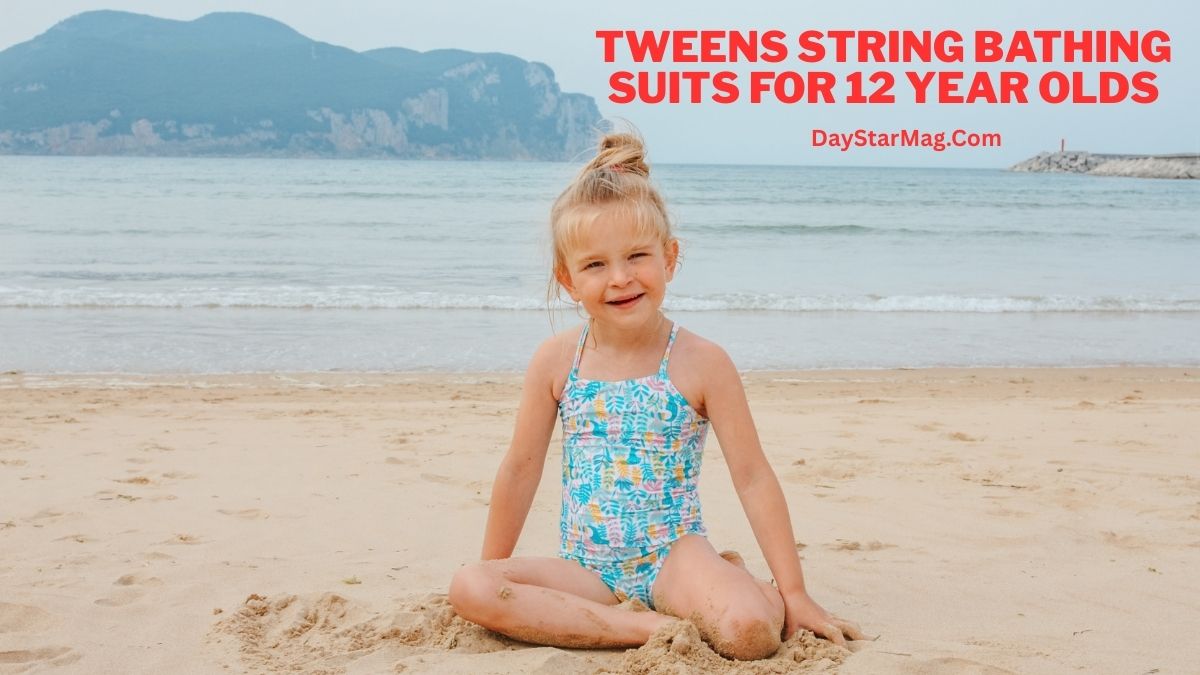 Smiling young child sitting on a sandy beach near the ocean, wearing a colorful one-piece swimsuit, with calm sea and mountains in the background and text reading “Tweens String Bathing Suits for 12 Year Olds – DayStarMag.com.”